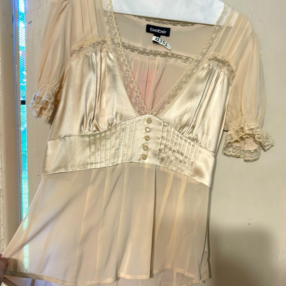 Medium BEBE beige blouse. Sheer. lace cuff edging and 5 button embellishments